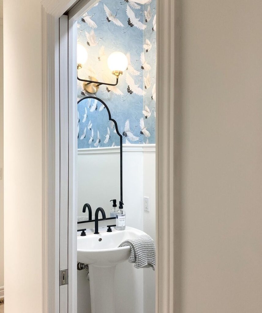 The entrance of a powder room, displaying bird-printed, unique wallpaper installation in London Ontario.